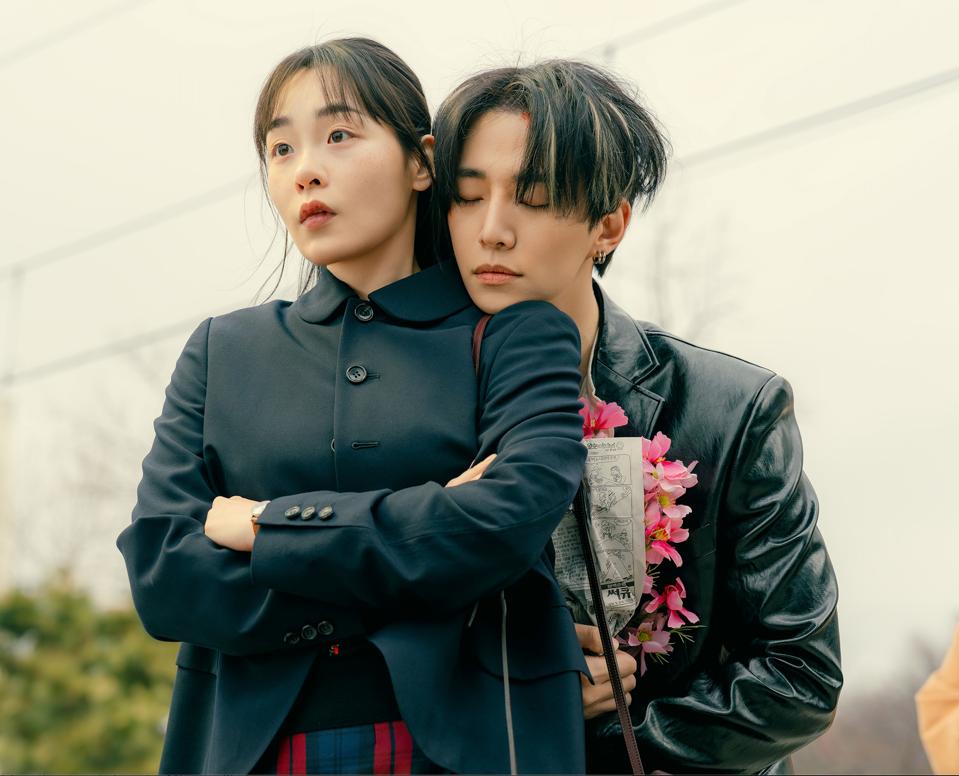 A man rests his chin on a woman's shoulder.