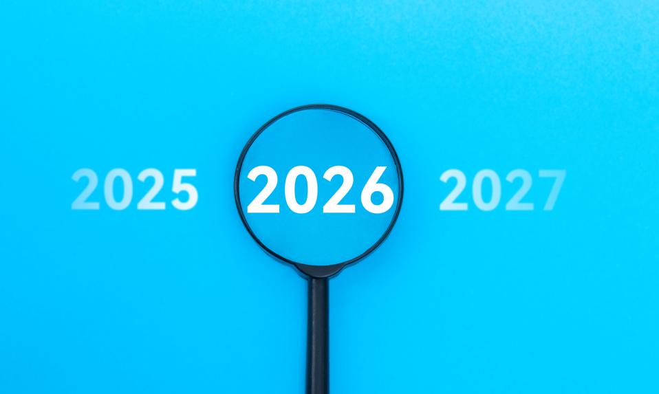 Top view of a magnifier focuses on new year 2026 against blue background