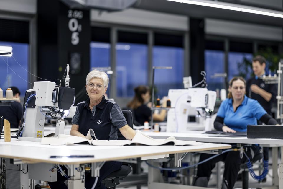 Broad stitching tables with industrial sewing machines. 