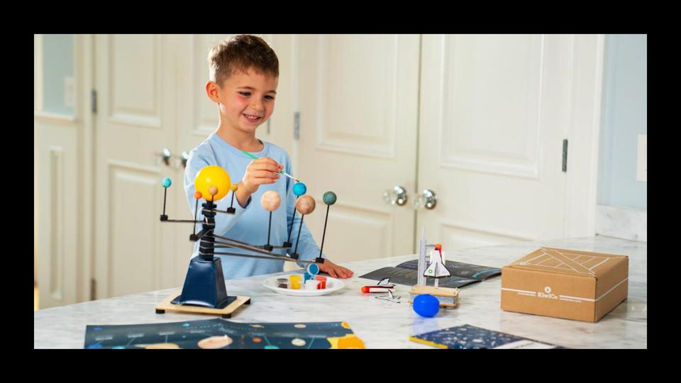 Young child playing with a space-themed Kiwico subscription box 