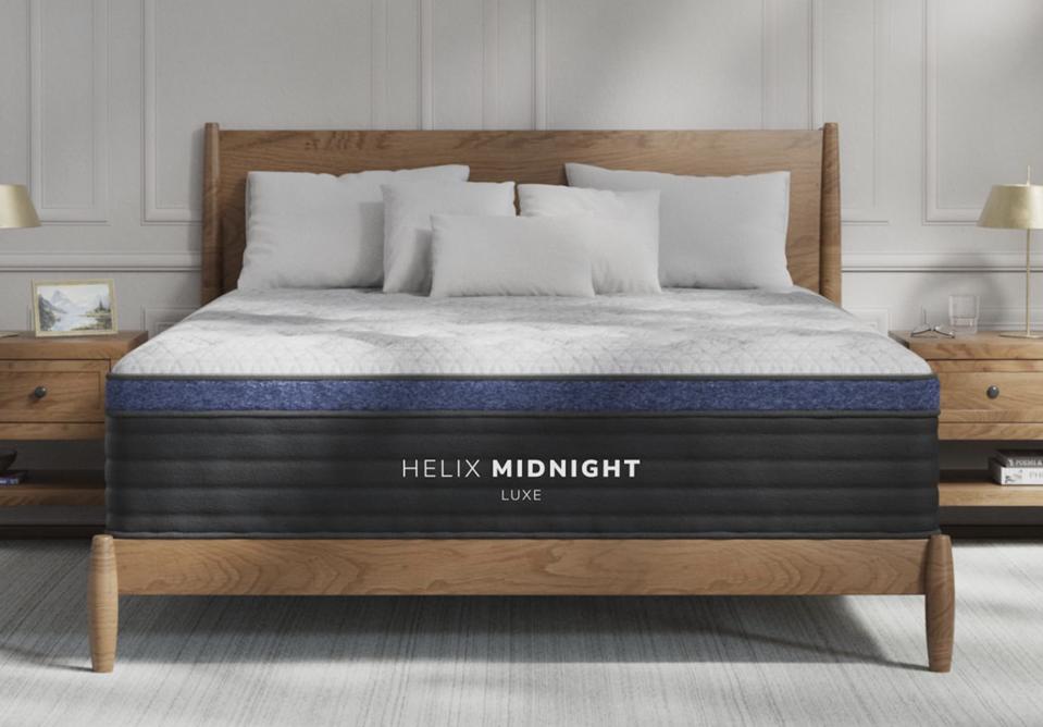 The Helix Midnight Luxe on top of a wooden bed frame. 