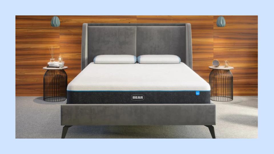 A Bear Mattress sits on a suede bed frame in a minimal bedroom.