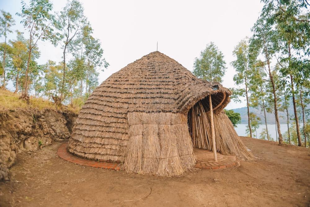 A brown thatched and domed hut sits on the shore of Lake Kivu in Rwanda, Africa