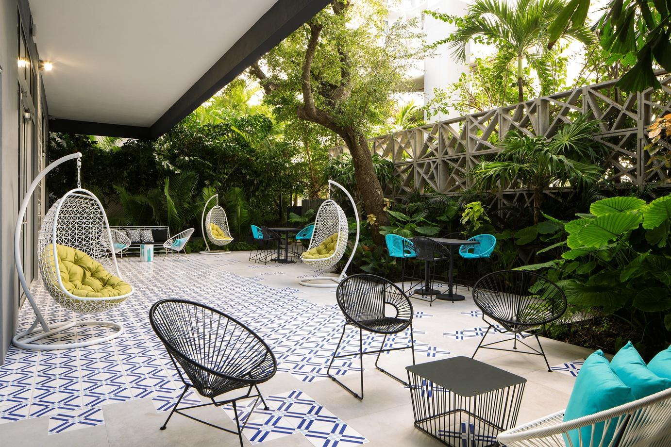 Patio filled with seating and greenery at Hotel Indigo Miami Brickell.