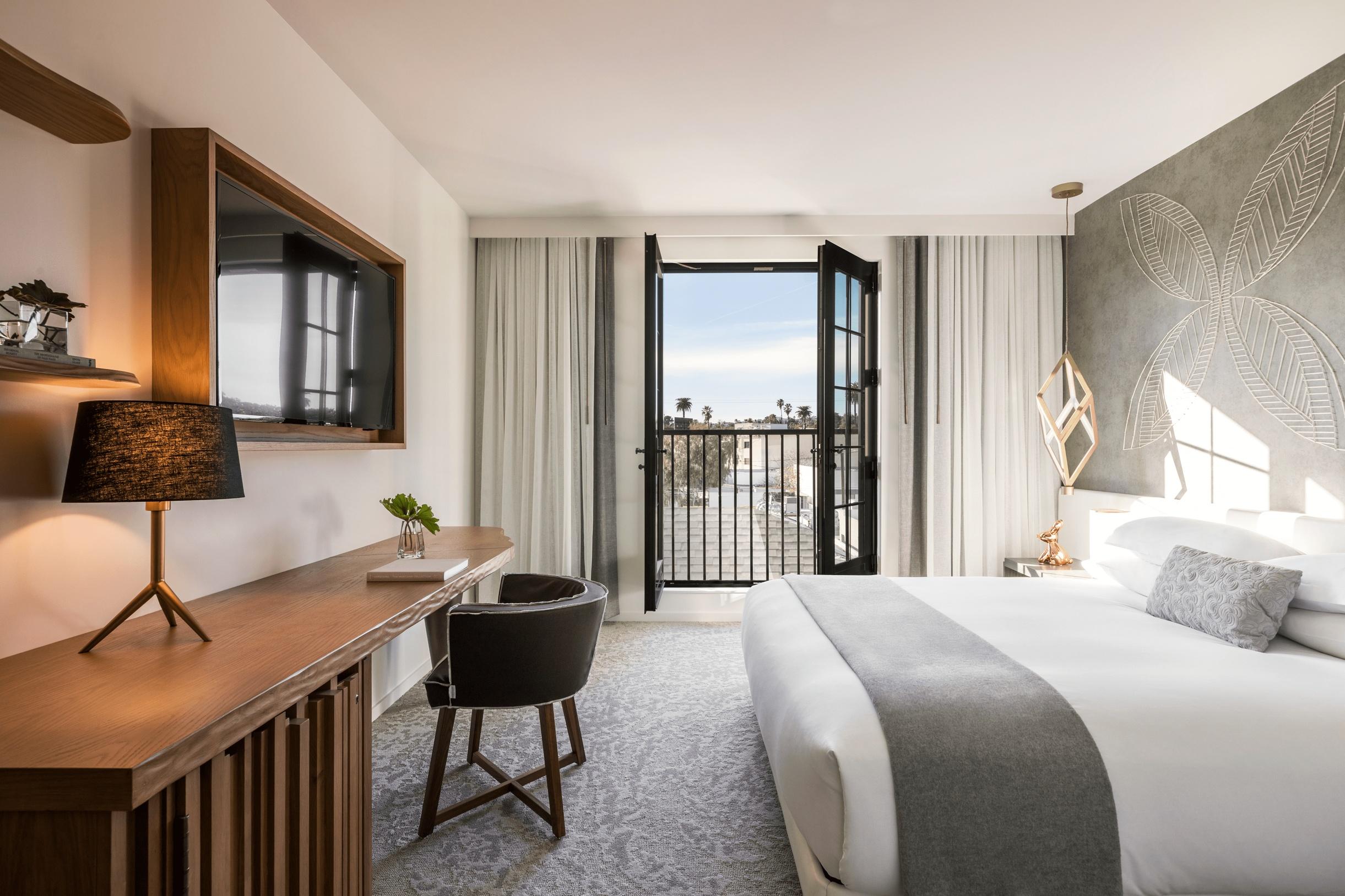 Kimpton La Peer guest room with king bed and dark wood desk