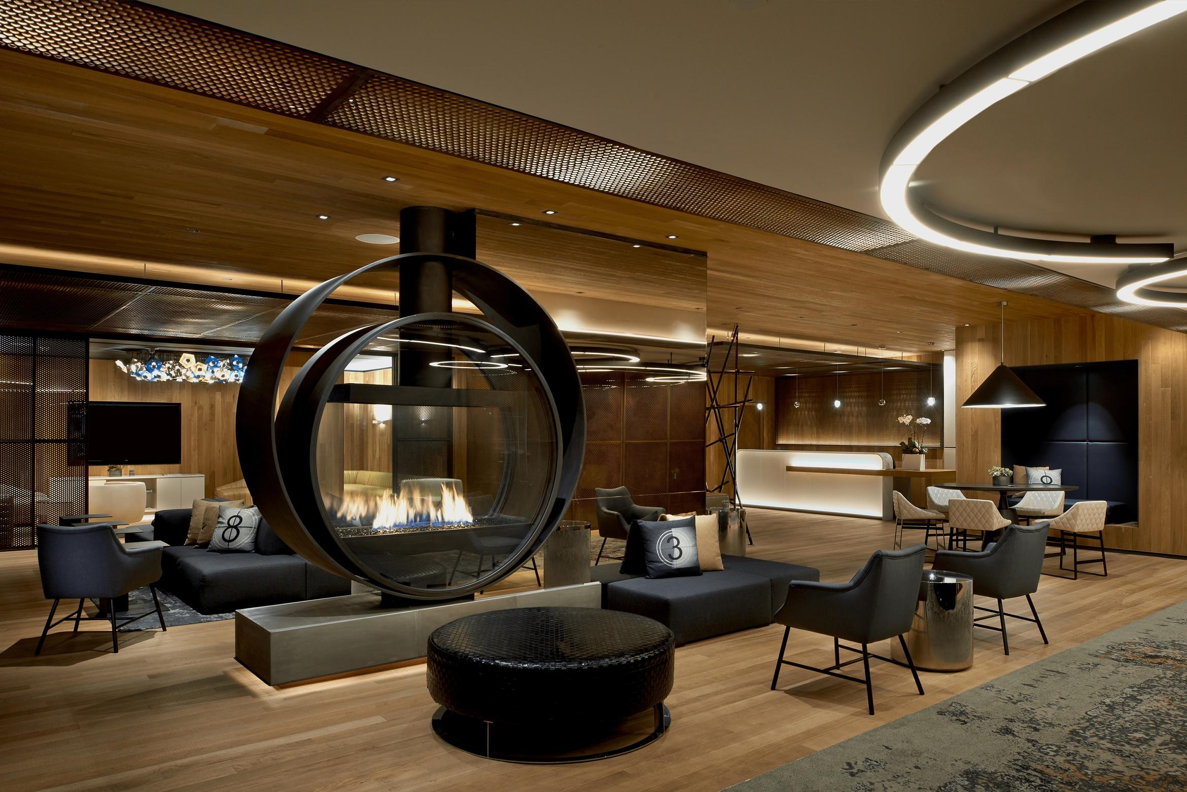 The lobby at the Kimpton Hotel Palomar Beverly Hills with wood paneling and a fire pit