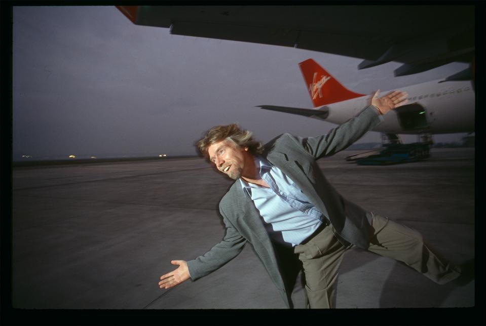 Richard Branson, chief executive officer of the Virgin corporation, celebrates the acquisition of Virgin Atlantic Airways' first airplane. The company purchased an Airbus A340 airplane, manufactured by Airbus Industrie.