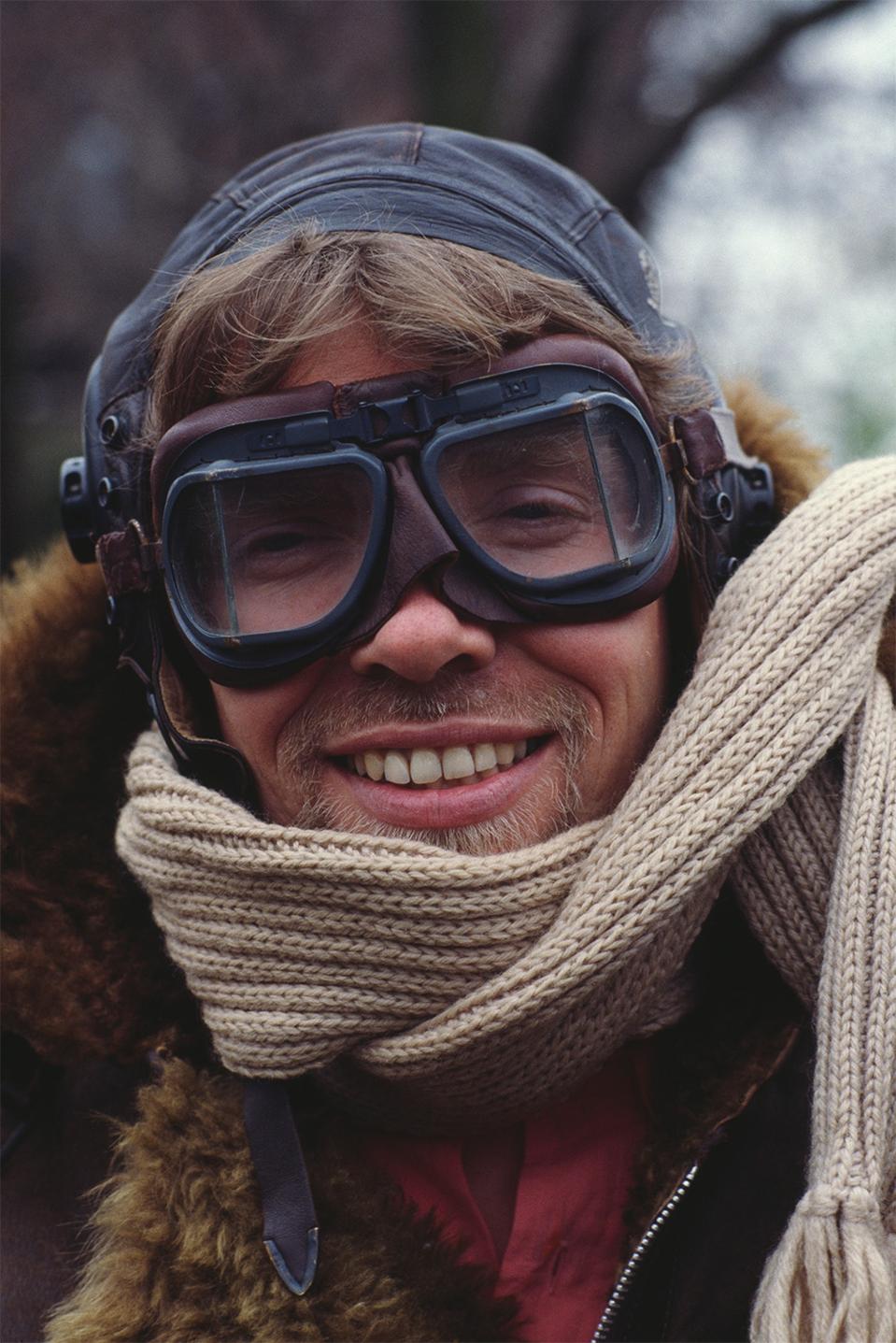 English business magnate, investor and philanthropist Richard Branson, co-founder of Virgin Atlantic Airways, poses in leather flying jacket and helmet during a news conference to launch the airline at Kensington Roof Gardens in London, UK, 5th April 1984.