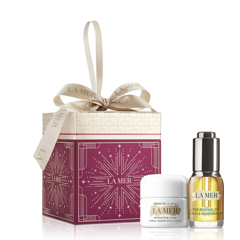 La Mer The Essentials Set with emerald-green bag on a beige background