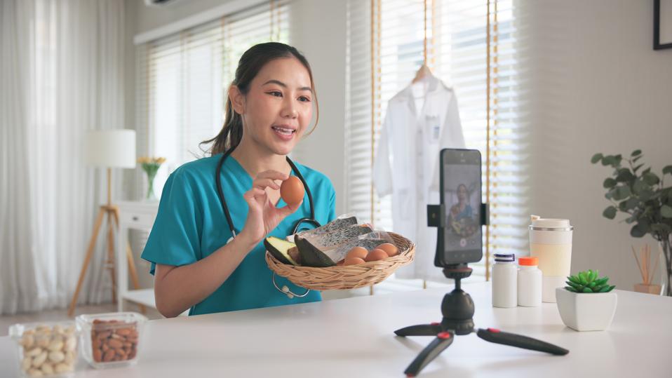 Asia woman people anti aging expert modern health care vlogger live advice talk selfie video mobile phone camera. Online diet food weight loss HDL meal plan recipe digital virtual asian coach filming.