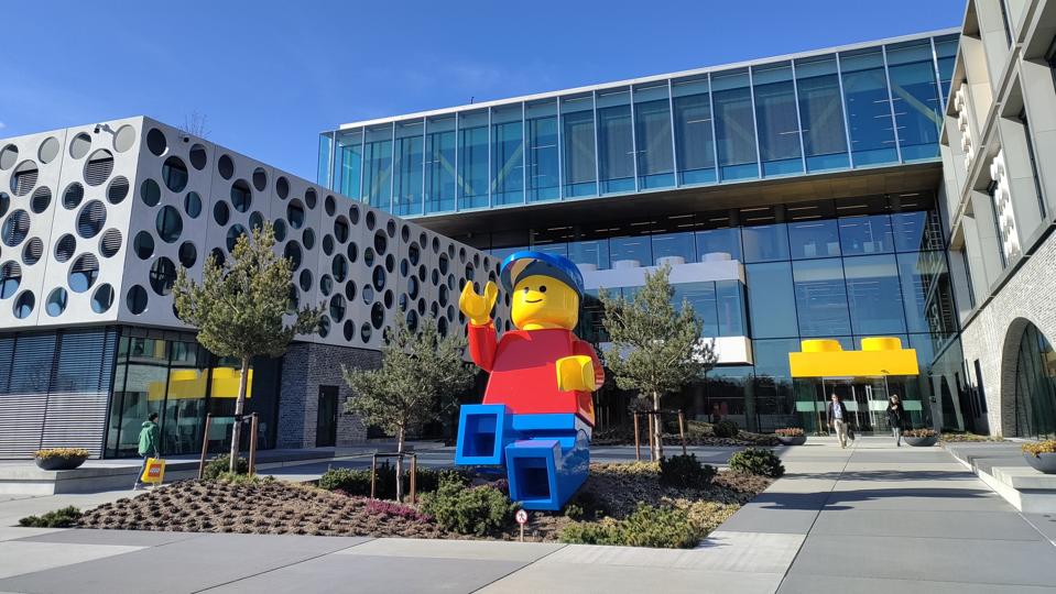 LEGO Group's HQ in Billund, Denmark, with a massive LEGO man outside.