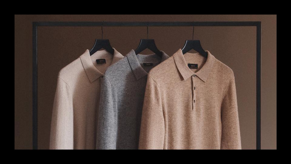 Three Quince cashmere sweaters hanging. 