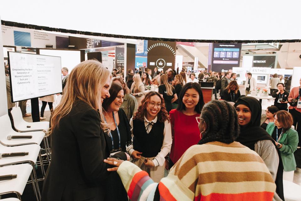 Group of women standing in a circle smiling and laughing