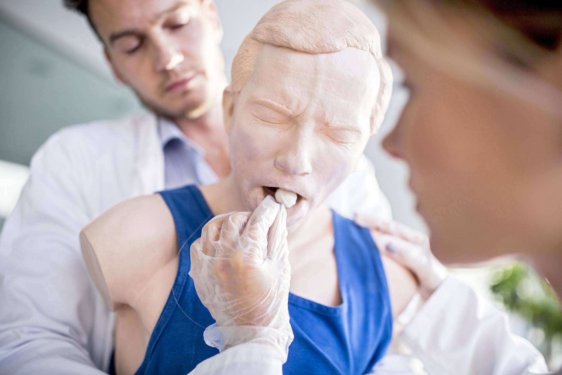 Doctor practising Heimlich manoeuvre