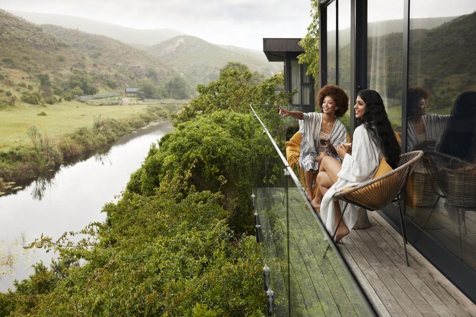 Smiling woman pointing away to female friend