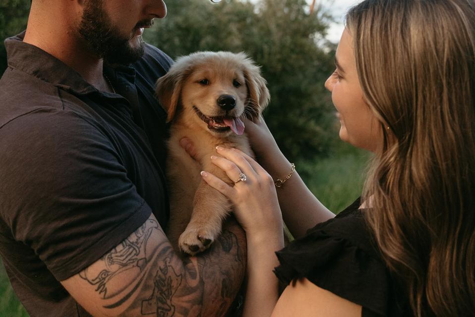 Keely Gaffney and Nash Morgan hold golden retriever puppy Dunkin.