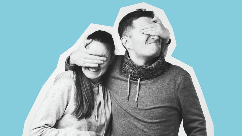 Portrait of a happy young couple, man and woman covering eyes of each other.