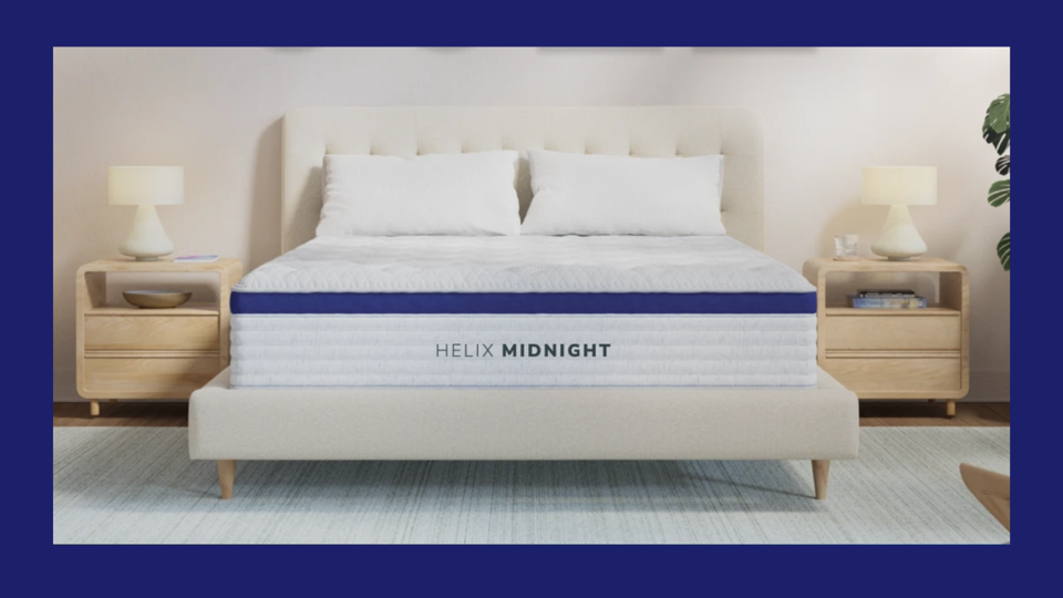 A Helix Midnight mattress on a white bed frame with two wooden nightstands on either side.