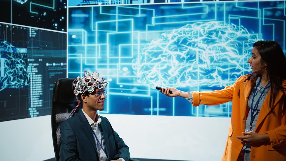 Presenter at AI convention showing EEH headset demonstration