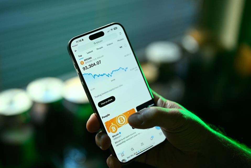 Person checking bitcoin ETF price data on a smartphone app, representing digital assets in retirement investing.
