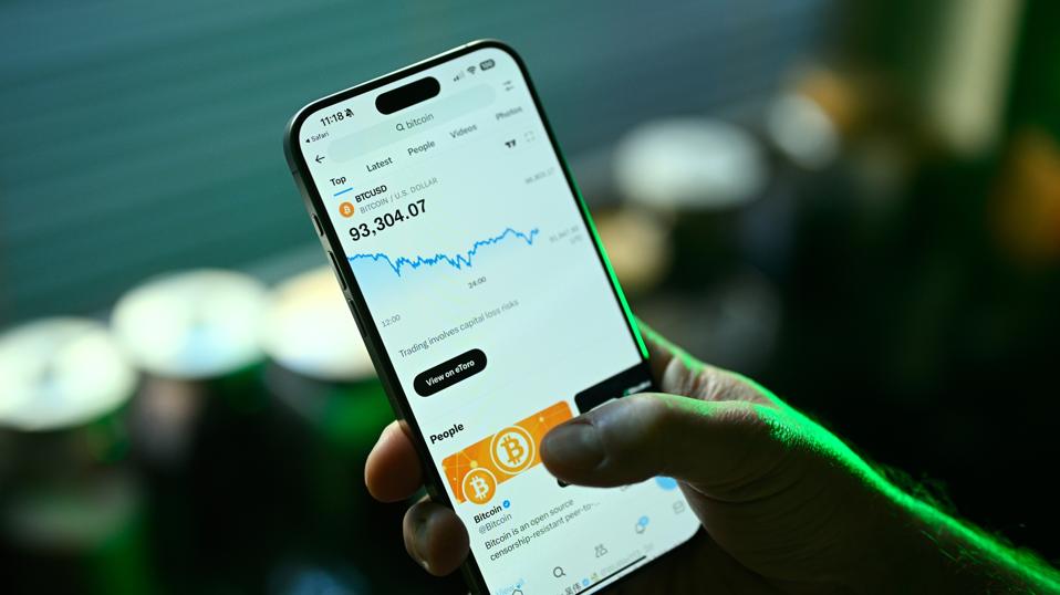 Person checking bitcoin ETF price data on a smartphone app, representing digital assets in retirement investing.
