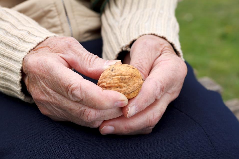 Cerca de una mano de anciano sosteniendo nueces