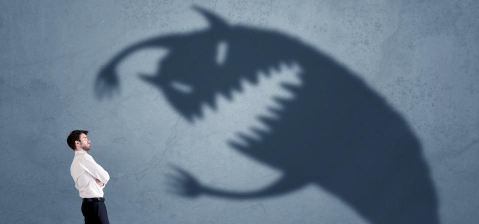 Business man afraid of his own shadow monster concept