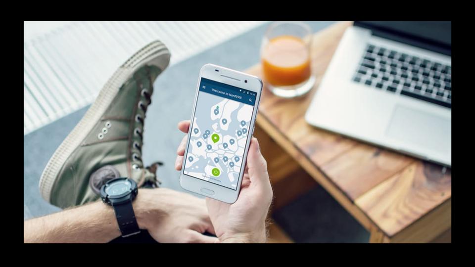 A person holding a cell phone showing a map with location markers on the screen.
