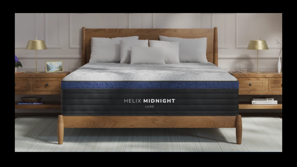 Helix Midnight Luxe mattress on wood bed frame with wood night stands on each side.