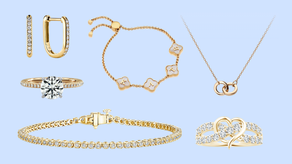 An assortment of gold jewelry against a light blue background