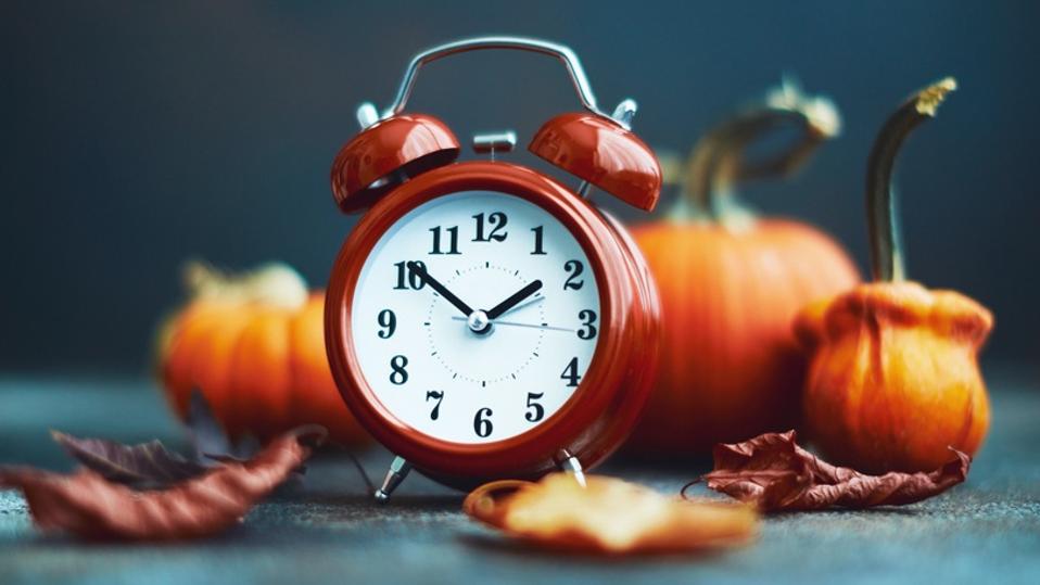 Time for Fall. Red alarm clock with leaves and pumpkins