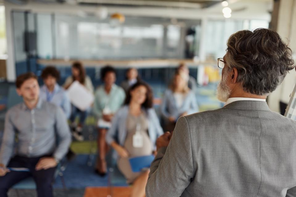 Back view of a businessman giving a speech on a seminar.