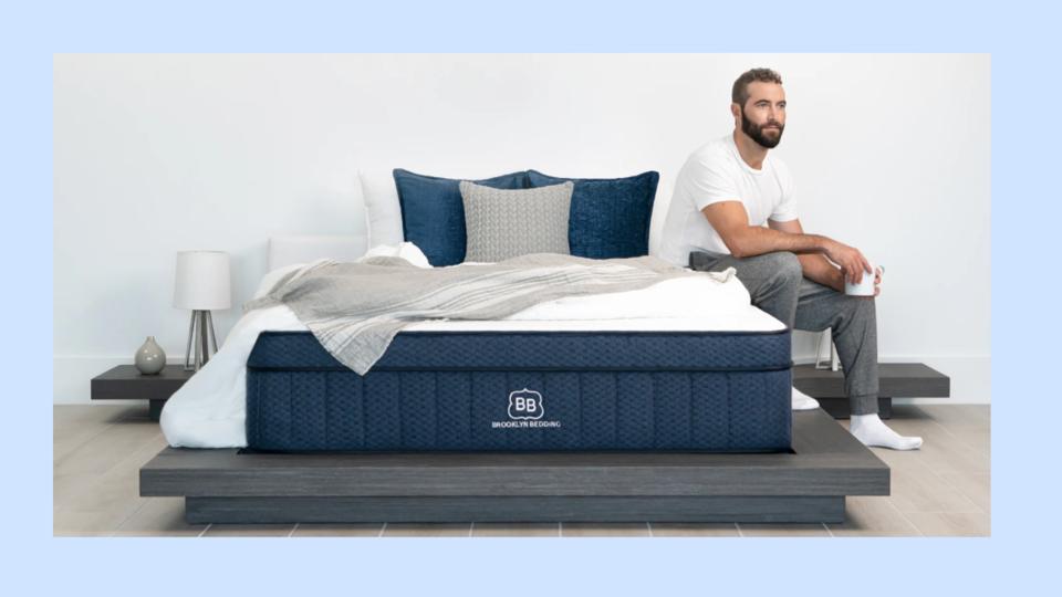 Man sitting on a Brooklyn Bedding mattress.