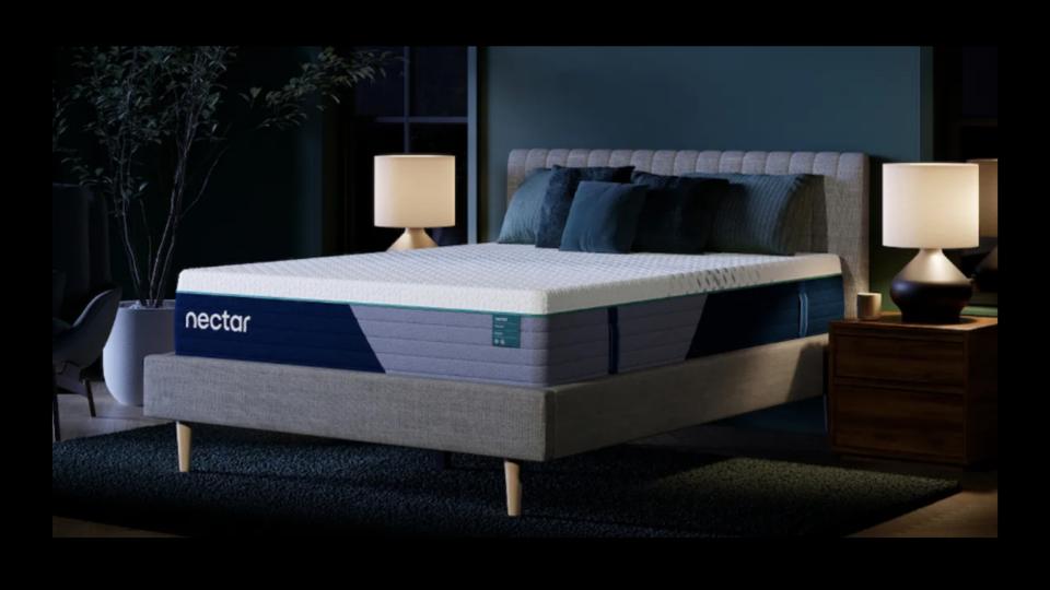 Lifestyle photo of a Nectar Premier Hybrid Mattress in a dark bedroom.