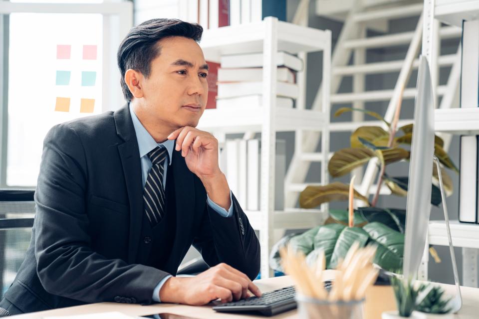Business coach working on his blog in the office.