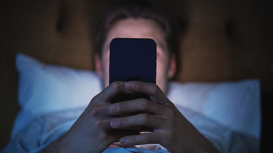 Anonymous Man Uses Smartphone in Bed