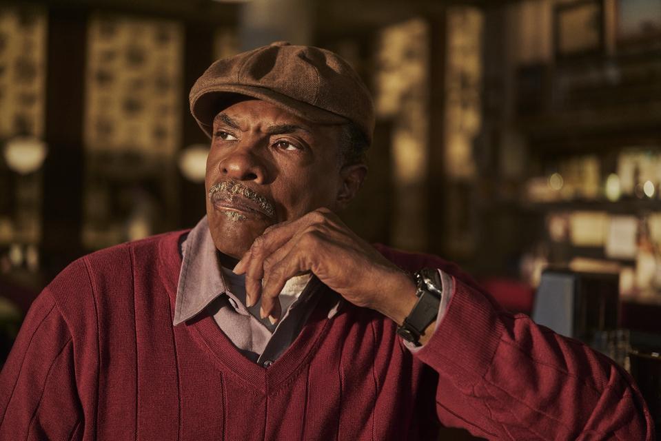 Marty Brunner’s signature look in The Lowdown Keith David as Marty in The Lowdown wearing a red sweater and tan cap