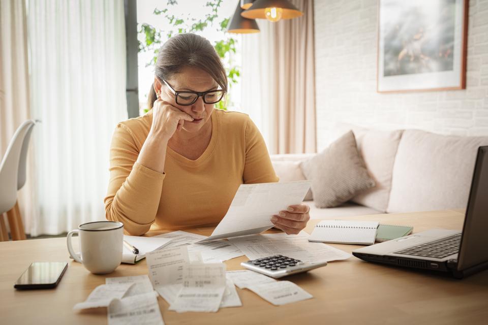 Serious woman checking bills and preparing tax papers