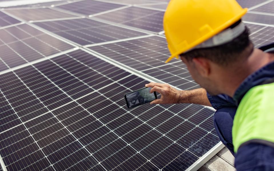 इंजीनियर सेल फोन का उपयोग करके सौर ऊर्जा स्टेशन की दक्षता पढ़ रहा है