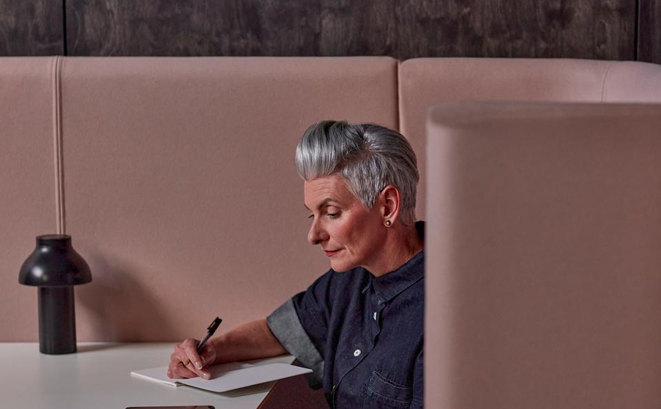 Woman in her 50's using a notebook at work