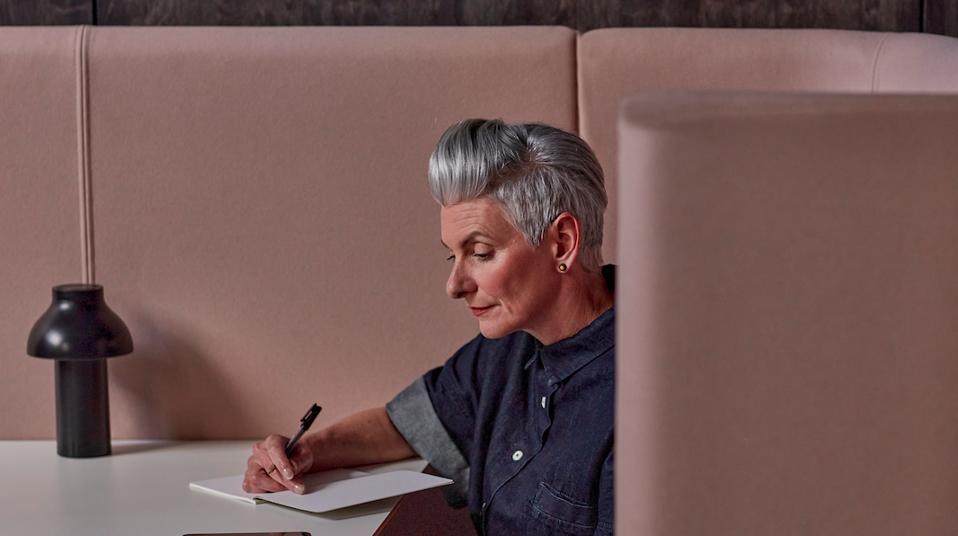 Woman in her 50's using a notebook at work