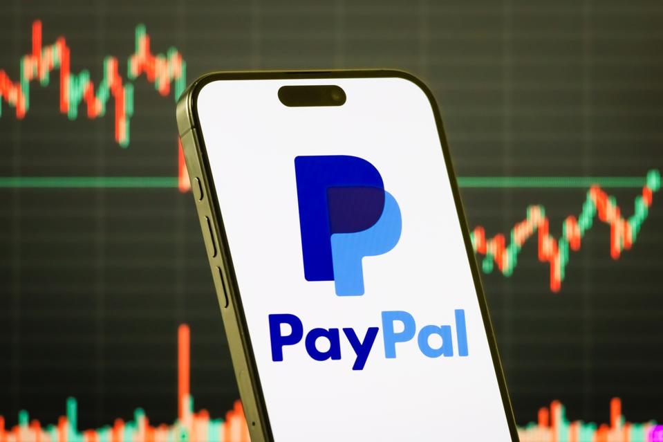 PayPal Holdings Inc. logo on smartphone with stock market chart background