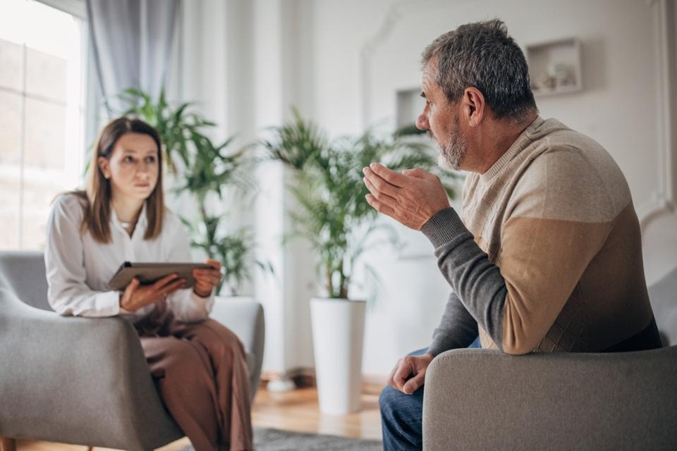 Psychotherapy, young woman doctor talking to an older man