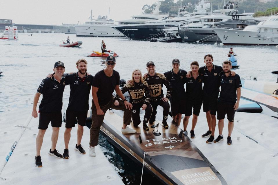 टॉम ब्रैडी और टीम ब्रैडी क्रू E1 रेसबर्ड पर खड़े हैं।