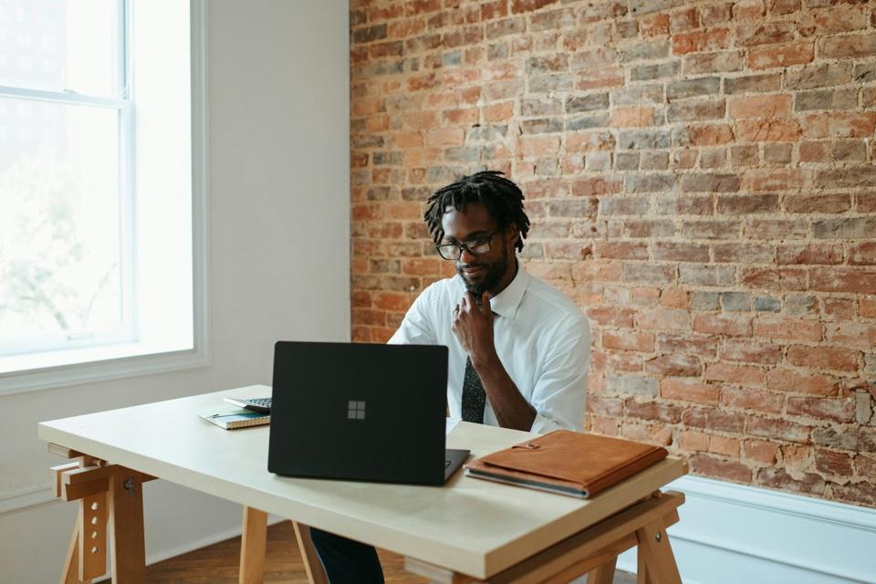 A person working on a laptop with creative visuals on the screen, representing strategic thinking.