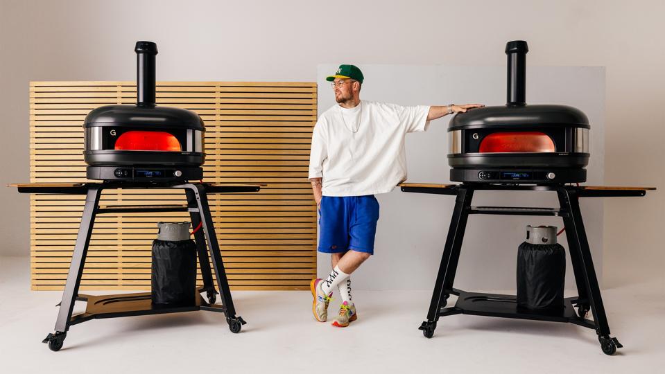 Tom Gozney posing with two Gozney Dome pizza ovens.