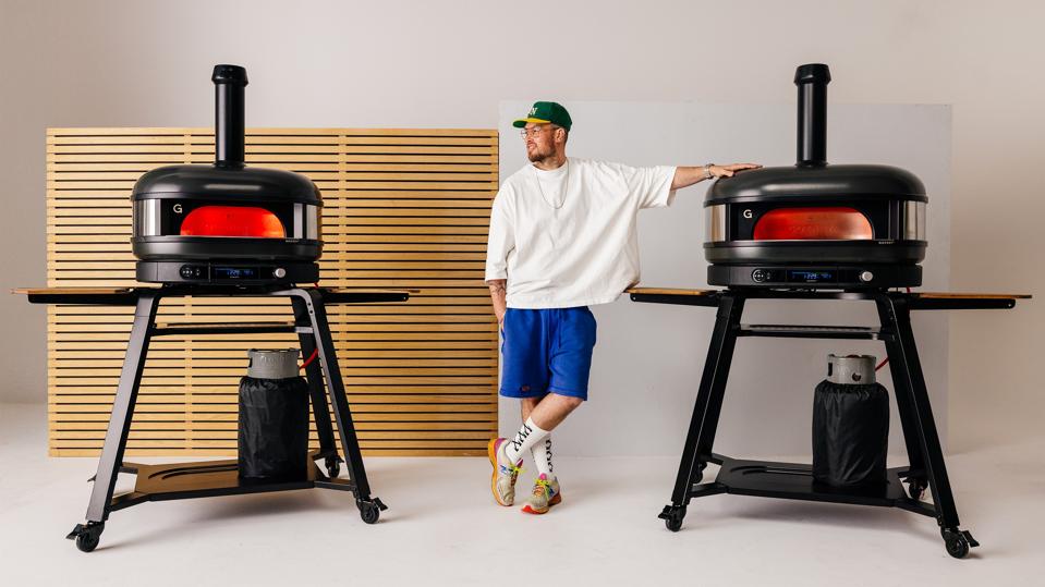 Tom Gozney posing with two Gozney Dome pizza ovens.