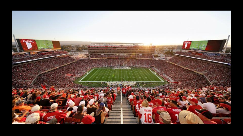 Crowded football stadium with fans dressed in red and white clothing.
