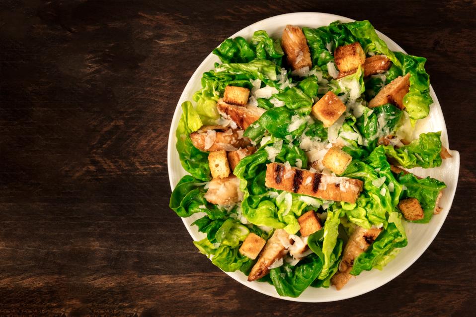 Chicken Caesar salad on rustic background with copyspace