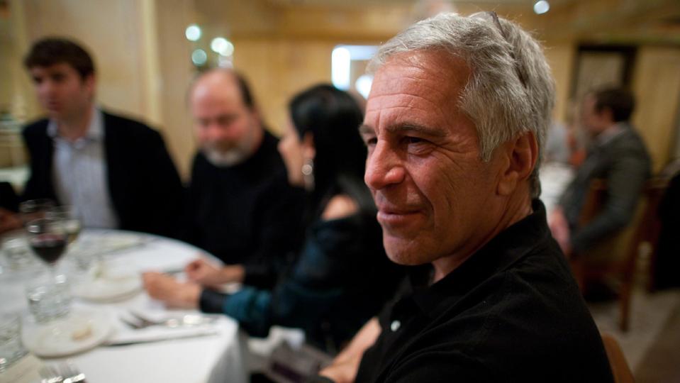 Jeffrey Epstein sitting at table